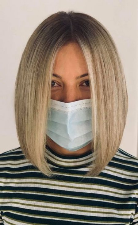 Lady in stripy top with a face mask having her hair blonde at the klinik salon London