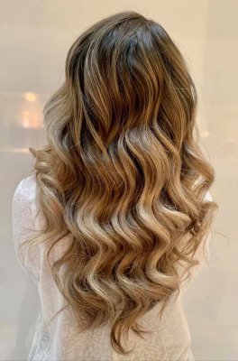 Long blonde hair being curled with soft glamourous waves at the klinik 