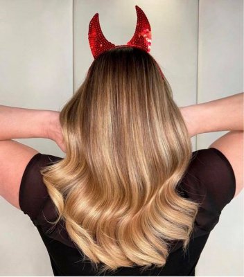 Long blonde hair sofly waved with red devil horns for Halloween at the klinik salon London