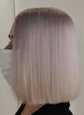 Icy white hair on a shoulder length bob on a lady wearing a face mask.