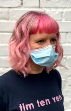 Girl with three shades of pink with a bold fringe wearing a black t-shirt at the klinik salon London