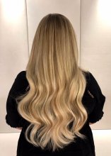 Blonde hair being extended using 120 strands of Easilocks system to give a natural soft long blended look by Leyla at the klinik hairdressing in London